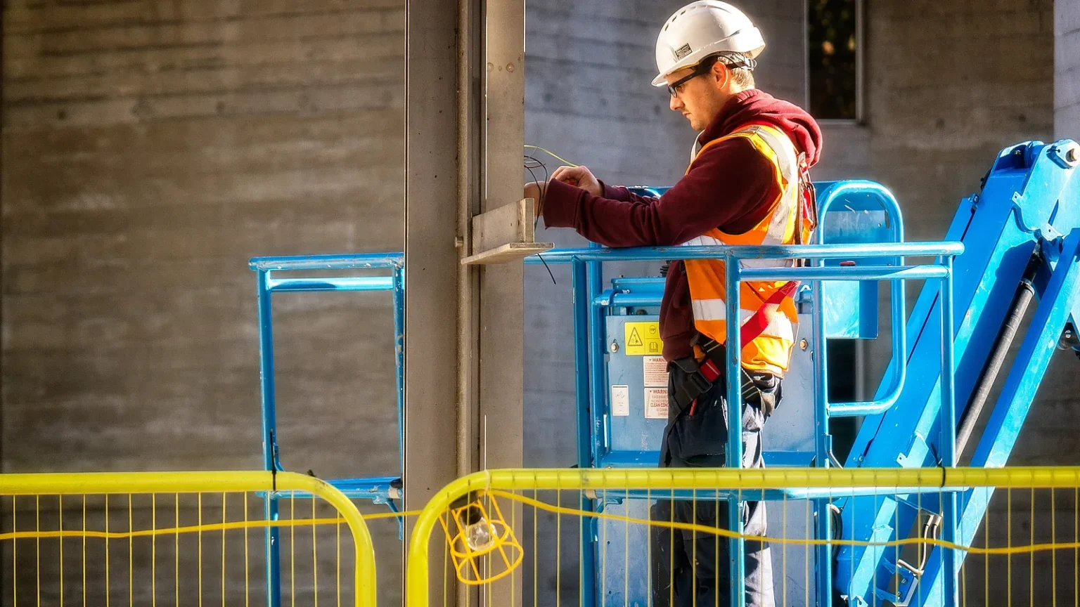 Factura rectificativa: electricista autónomo trabajando en una plataforma elevadora